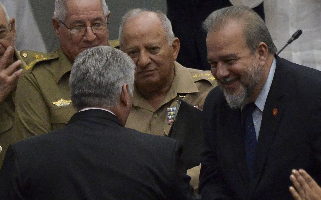 Cuban Prime Minister Manuel Marrero Cruz (R) greets Cuban President Miguel Diaz Canel (L-back to camera) during the closing of the Fourth Regular Session of the National Assembly of People's Power in its 9th Legislature at the Havana Convention Center on December 21, 2019.