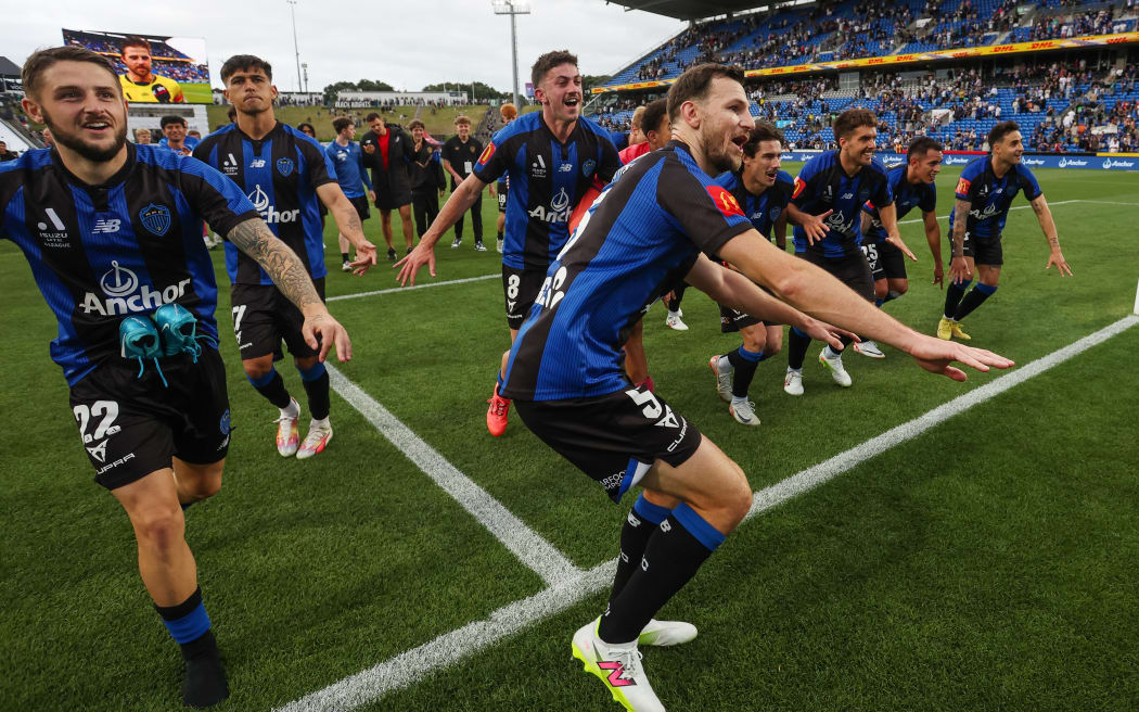 Auckland FC players celebrate victory over Wellington Phoenix with their fans, Dec 2024.