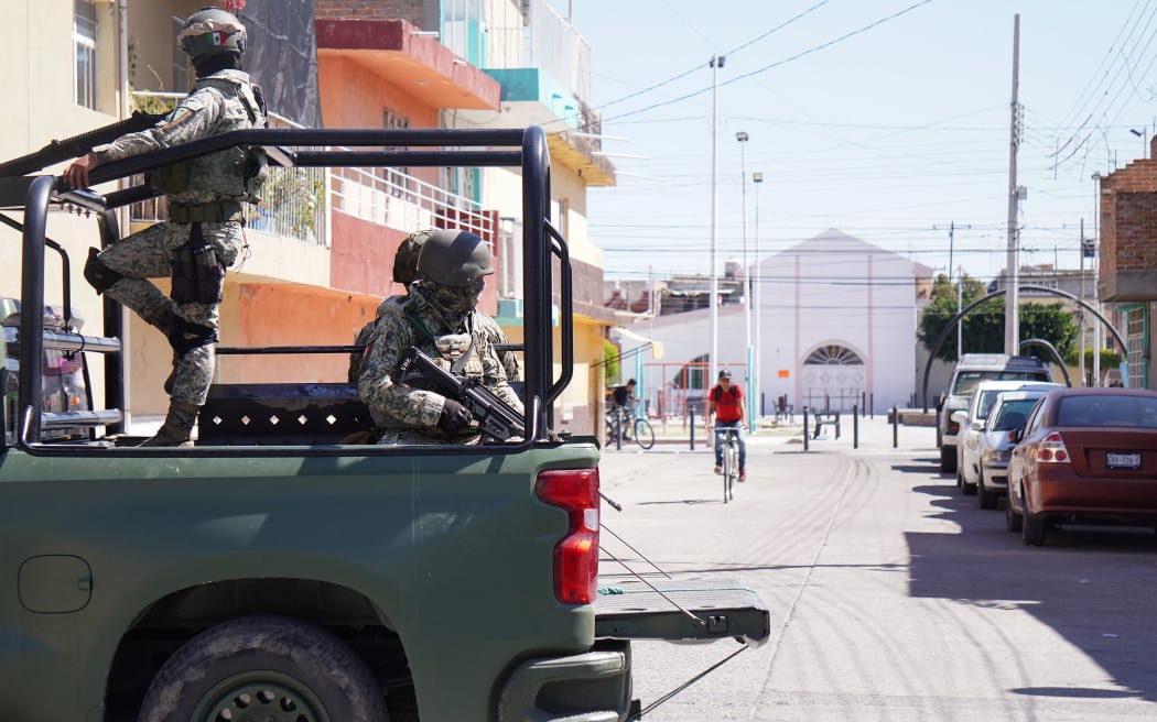 Mexican Army soldiers patrol a street a day after an armed attack on a playground in San Francisco del Rincon, Guanajuato state, Mexico on February 18, 2026. An armed attack in the state of Guanajuato, in central Mexico, left a 36-year-old man dead and at least eight youths injured on a playground on February 17, 2026, another violent episode in the region that provoked terror among local neighbors. (Photo by MARIO ARMAS / AFP)