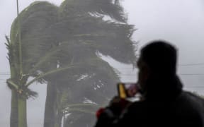 A man live streams as gusts from Hurricane Ian hits in Punta Gorda, Florida on September 28, 2022. - Hurricane Ian slammed into Florida September 28, 2022, with the National Hurricane Center saying the eye of the storm made landfall at 1905 GMT as high winds and heavy rain pounded the coast. (Photo by Ricardo ARDUENGO / AFP)