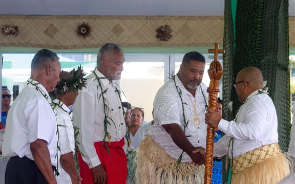 Outgoing Ulu o Tokelau Esera Fofo Tuisano shakes hands with Alapati Pita Tavite during the inauguration