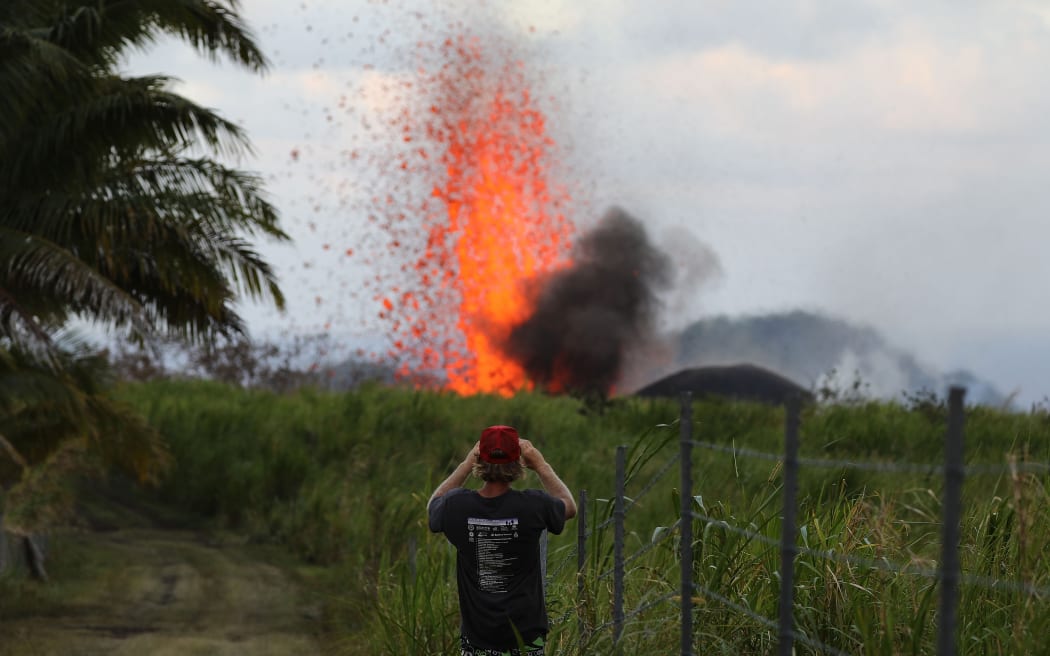 A man takes a photo of a lava fountain from a Kilauea volcano fissure on Hawaii's Big Island