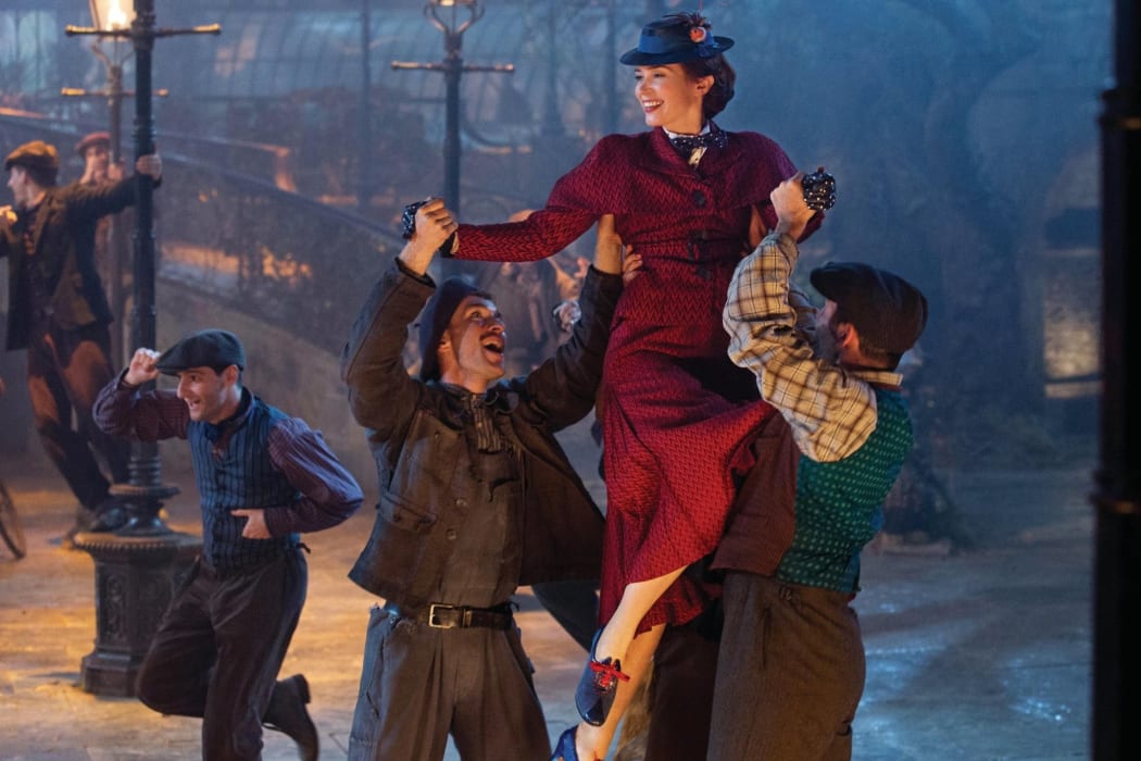 Mary Poppins serenaded in ‘Gor Blimey, Guvnor’ fashion by the lamplighters in Mary Poppins Returns.