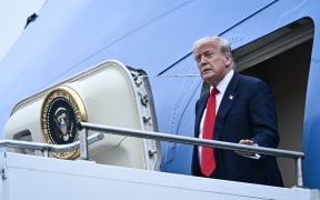 US President Donald Trump disembarks from Air Force One upon his arrival at Prestwick Airport, south of Glasgow on July 25, 2025, on the first day of his UK visit. US President Donald Trump departed for Scotland on July 25, 2025 for a mix of diplomacy, business and leisure, as a huge UK security operation swung into place amid planned protests near his family-owned golf resorts. (Photo by Brendan SMIALOWSKI / AFP)