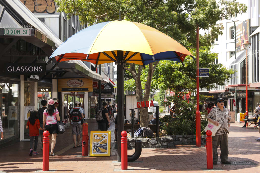 Summer in Wellington, Cuba Street. A man seeks shelter from the sun.