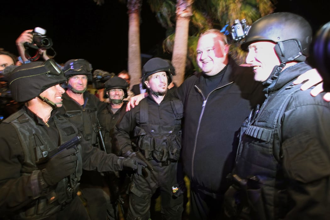 Megaupload founder Kim Dotcom (2nd R) poseswith actors dessed as police after the launch of his new website at a press conference held inside his home in Auckland on January 20, 2013.