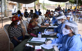 Member of the medical team of the Armed Forces of Brazil examines a man of the Guajajara indigenous ethnicity during the Covid-19 pandemic on 3 October, 2020.