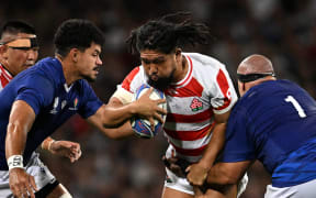 Japan's hooker Shota Horie (C) is tackled by Samoa's loosehead prop James Lay (R) and Samoa's lock Theo McFarland (L) as he runs with the ball during the France 2023 Rugby World Cup Pool D match between Japan and Samoa at the Stadium de Toulouse in Toulouse, southwestern France on September 28, 2023. (Photo by Lionel BONAVENTURE / AFP)