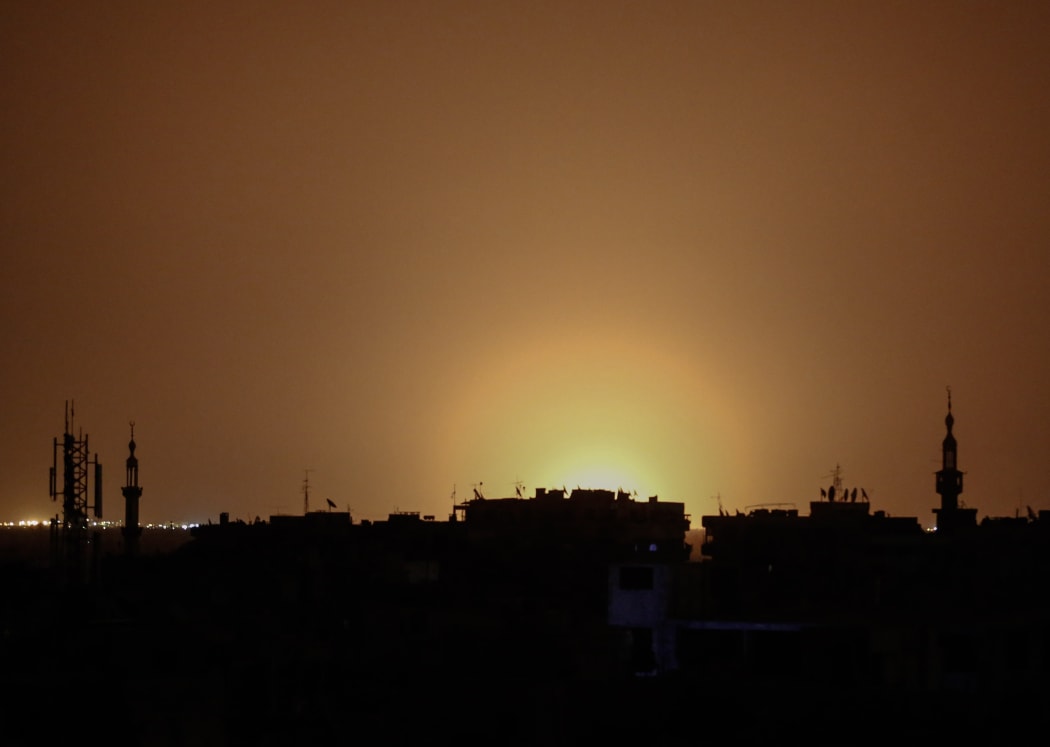 A photo taken from the rebel-held town of Douma shows flames rising in the distance which are believed to be coming from Damascus International Airport following an explosion.