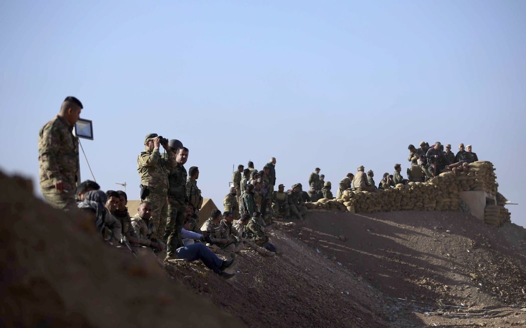 Peshmerga forces stand guard overlooking Mosul during an operation to liberate it from the Islamic State militant group.