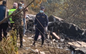 Rescuers gather at the site of a plane crash in Pokhara on January 15, 2023. - At least 67 people were confirmed dead on January 15 when a plane with 72 on board crashed in Nepal, police said, in the Himalayan country's deadliest aviation disaster in three decades. (Photo by Prakash MATHEMA / AFP)