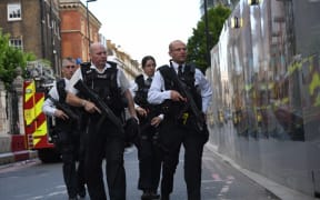 Armed police officers patrol the streets from Borough Market towards The Shard in London.