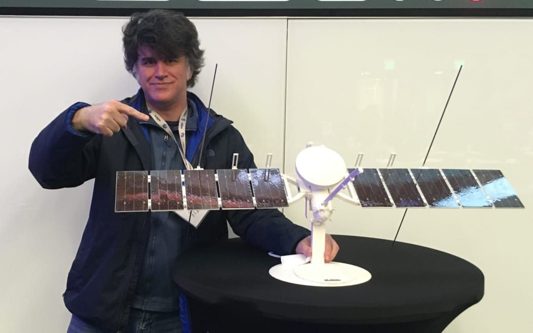 New Zealand scientist Duncan Young with a model of the Europa Clipper spacecraft in early 2022, pointing to a REASON radar antenna.