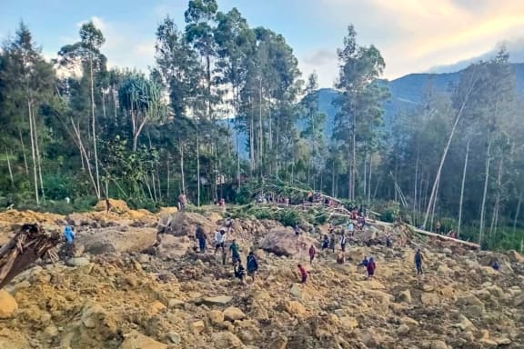 People gather at the site of a landslide in Maip Mulitaka in Papua New Guinea's Enga Province on May 24, 2024. Local officials and aid groups said a massive landslide struck a village in Papua New Guinea's highlands on May 24, with many feared dead.