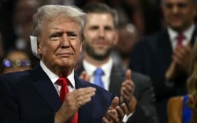 US former President and 2024 Republican presidential candidate Donald Trump, a bandage on his ear after being wounded in an assassination attempt, applauds during the first day of the Republican National Convention at the Fiserv Forum in Milwaukee, Wisconsin, 15 July, 2024.