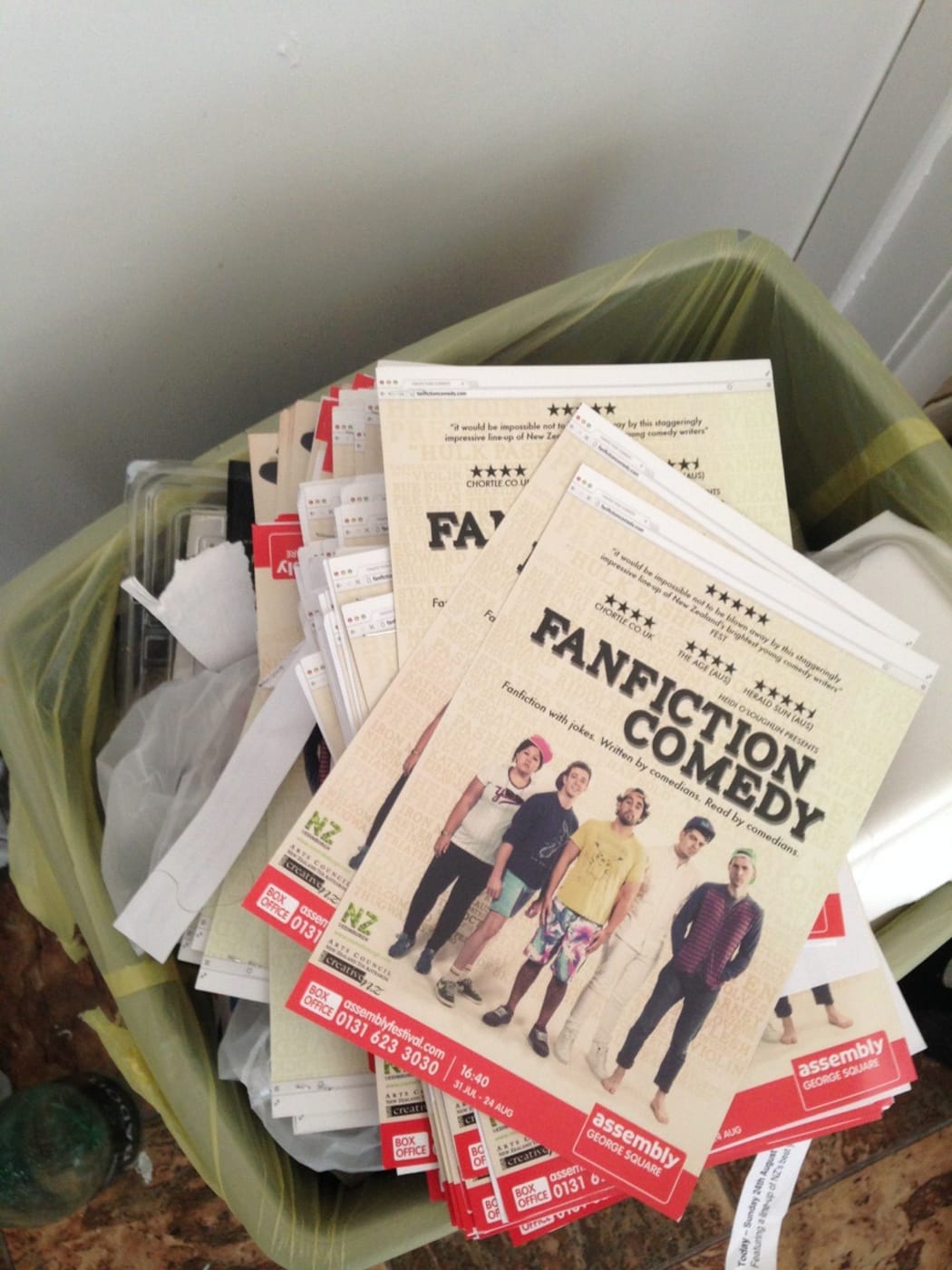 A picture of FanFiction Comedy flyers in a bin