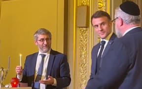 President Emmanuel Macron looked on as France's Chief Rabbi Haïm Korsia lit a candle for the first night of Hanukkah.