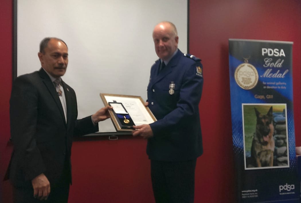 Senior Constable Lamb receives the PDSA gold medal for Gage.