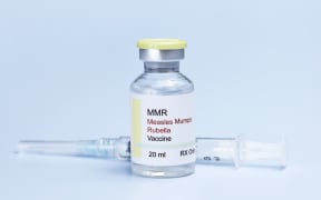 Measles, mumps, rubella, virus vaccine and syringe on blue background.