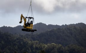 An excavator is helicoptered into a remote area of the SH3 Te Ara o Te Ata: Mt Messenger Bypass project site.