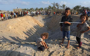 Palestinians inspect the damage at the site of Israeli strikes on a makeshift displacement camp in Mawasi Khan Yunis in the Gaza Strip on September 10, 2024, amid the ongoing war between Israel and Palestinian militant group Hamas. Gaza's civil defence agency said that an Israeli strike on a humanitarian zone in the south of the Palestinian territory killed 40 people and wounded 60 others, with the Israeli army saying it had targeted a Hamas command centre in the area. (Photo by Bashar TALEB / AFP)