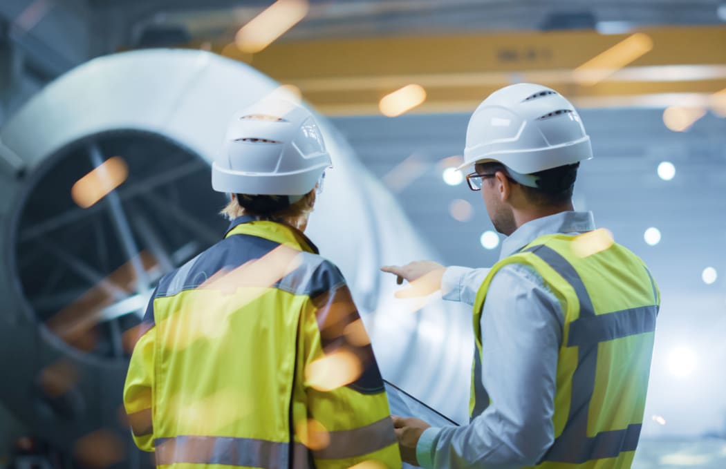 Two Heavy Industry Engineers Stand in Pipe Manufacturing Factory,