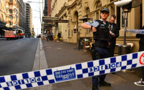 Police gather at the crime scene after a man stabbed a woman and attempted to stab others in central Sydney.