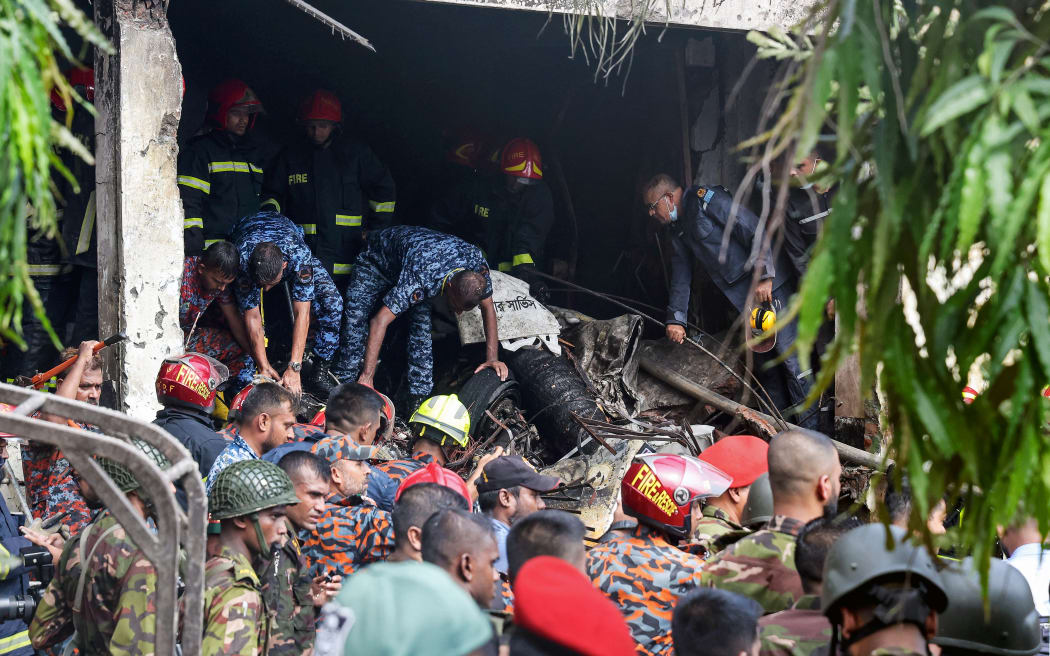 Bangladesh's fire service and security personnel conduct a search and rescue operation after a Air Force training jet crashed into school in Dhaka on 21 July, 2025.