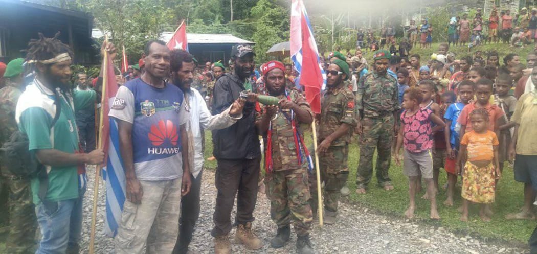 A West Papuan community from Pegunungan Bintang regency displays an apparent unexploded bomb found in its village following aerial attack, October 2021.