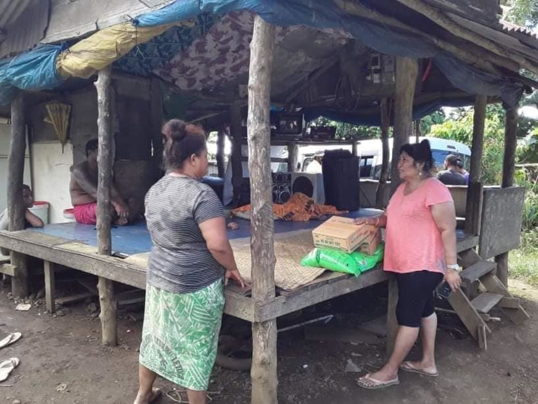 Lina Chang (right) visits a house for donated goods. Samoa Victim Support has been conducting regular welfare visits as hundreds of Samoans lose their jobs.