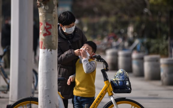 A woman cleans a boy's face in Wuhan,  Hubei province. The number of confirmed cases in the new virus outbreak in China reached 5,974 on 29 January.