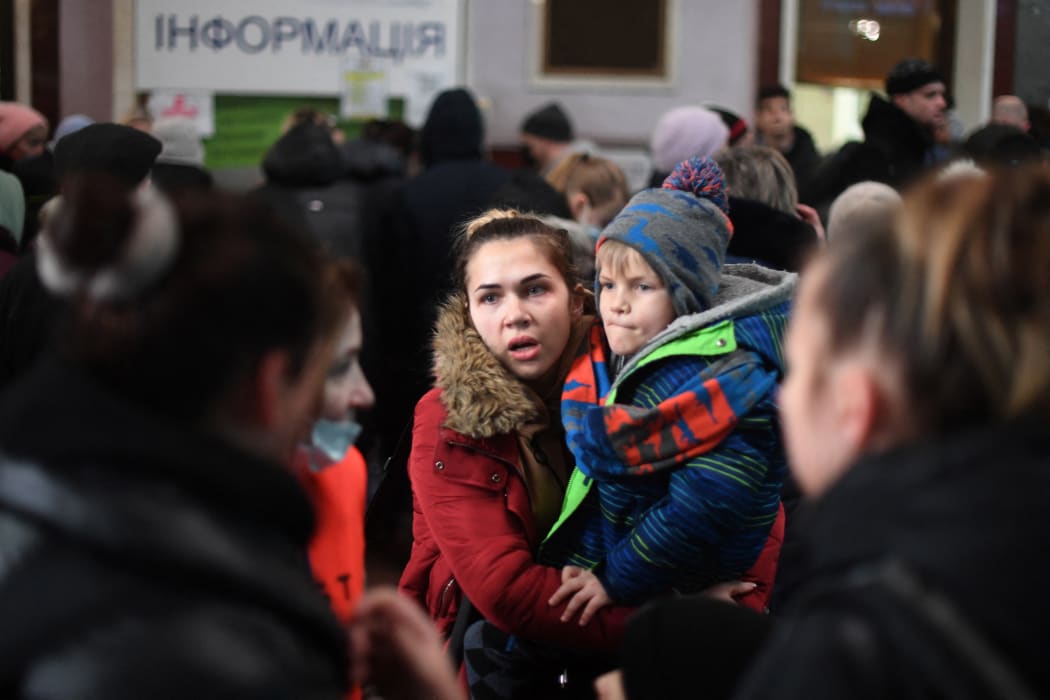 A woman carries a child at the train station in Lviv, western Ukraine, 3 March, 2022.