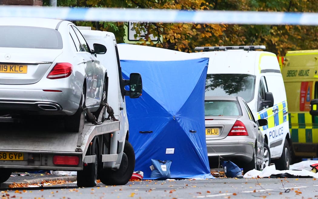 Police tents cover parts of the scene on the main road outside Heaton Park Hebrew Congregation synagogue in Crumpsall, north Manchester, on 3 October, 2025, following an attack at the synagogue the day before.