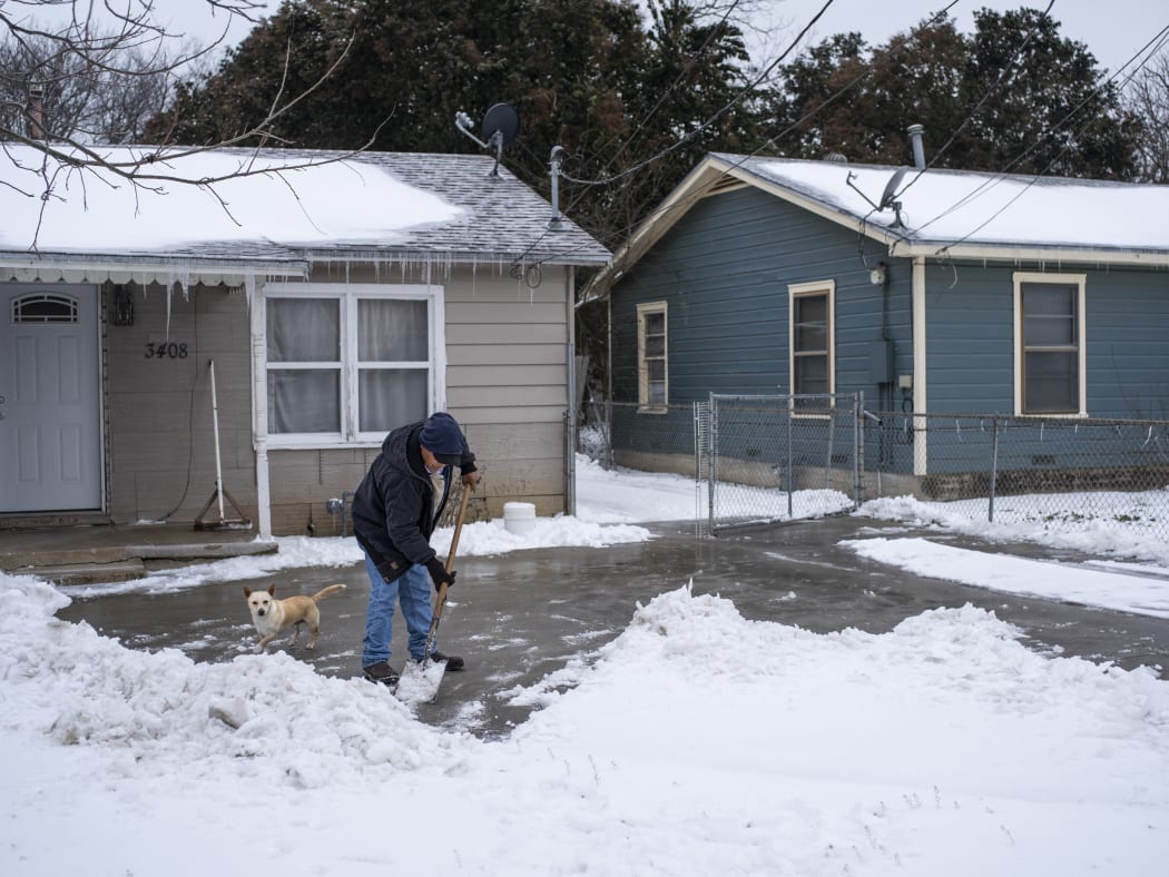 A Waco, Texas, resident clears snow from his driveway on 17 February 2021.