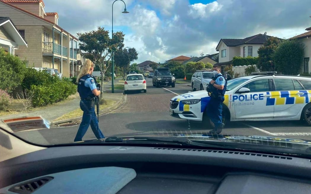 Armed police stand near Andrew Lamositele-Brown's Flat Bush home after the fatal shooting of Petau Petau and a seven-hour standoff. Photo / David Fisher