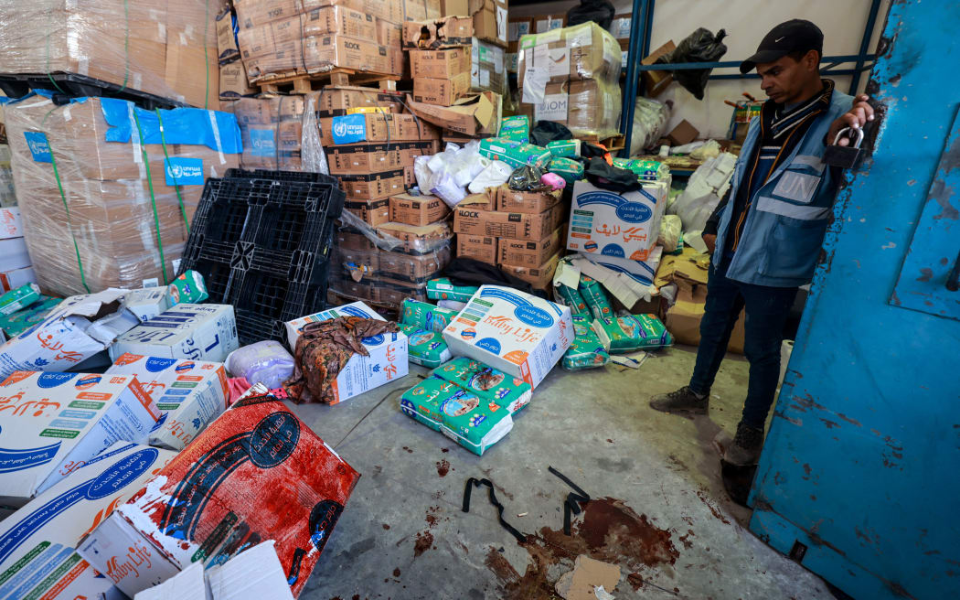 A UN (United Nations) staff stands near a pool of blood at an UNRWA warehouse and distribution centre in Rafah, in the southern Gaza Strip, following an Israeli strike on March 13, 2024, amid continuing battles between Israel and the Palestinian militant group Hamas. The UN agency for Palestinian refugees said one of its warehouses in war-ravaged Gaza was hit on March 13, amid mounting efforts to bring food to the besieged Palestinian territory. (Photo by MOHAMMED ABED / AFP)