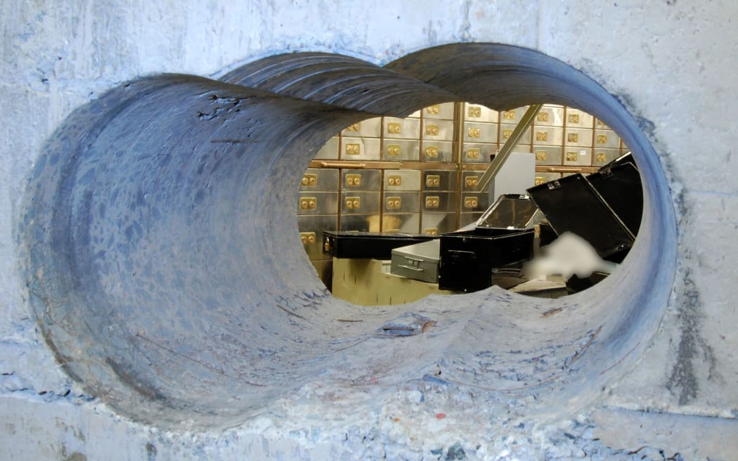 Holes bored through a half-metre thick concrete wall drilled to access the vault.