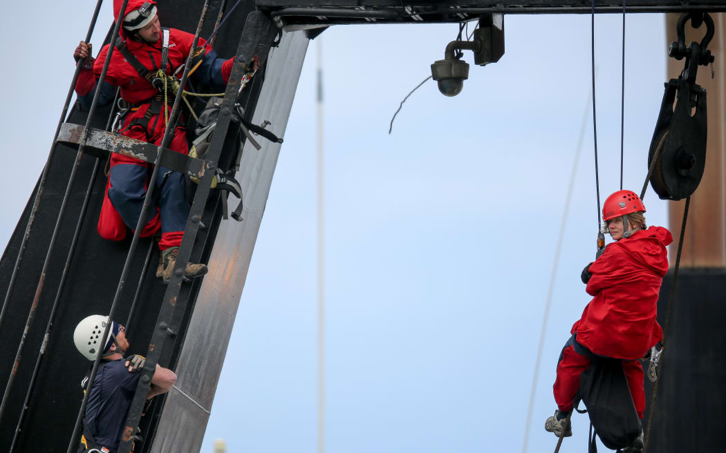 A police officer (bottom left) talks to Greenpeace activists on board the government research ship Tangaroa in Wellington.