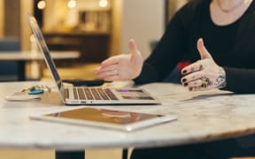 person gesturing near laptop