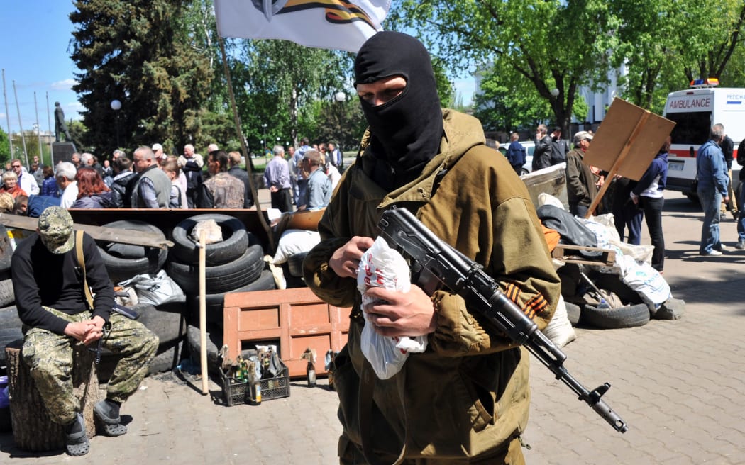 An Armed pro-Russian militiant guards a barricade outside the regional state building in Kramatorsk.