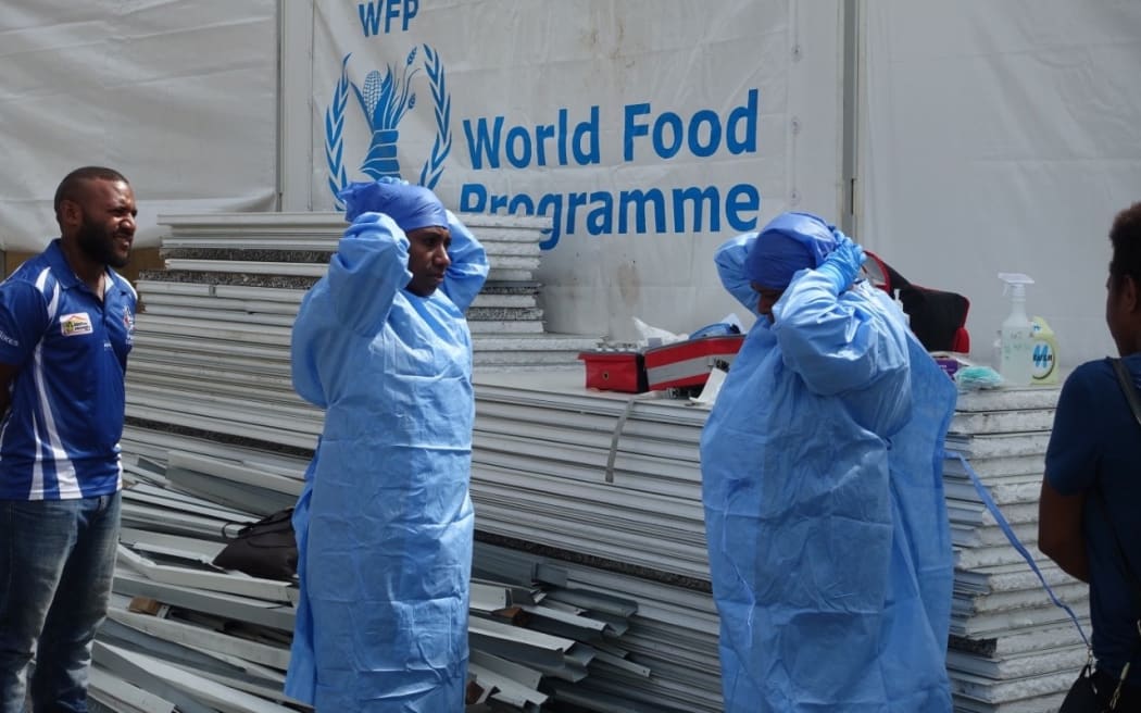 Health workers practice donning personal protective equipment (PPE).