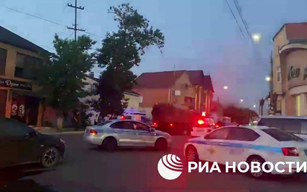 This screengrab picture taken from video released on June 23, 2024 by Russian state news agency RIA Novosti shows an area sealed off by Police following deadly attacks on churches and a synagogue in Russia's North Caucasus region of Dagestan. Gunmen on June 23, 2024 attacked synagogues and churches in the region of Dagestan, killing a priest, six police officers, and a member of the national guard, security officials said. The attacks took place in Dagestan's largest city of Makhachkala and in the coastal city of Derbent, where gunfights were ongoing.