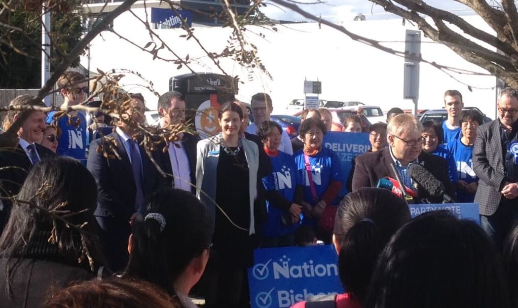 Lower Hutt Mayor Ray Wallace (behind the microphone) and Bill English (far left) at National's electric vehicle announcement in Lower Hutt.
