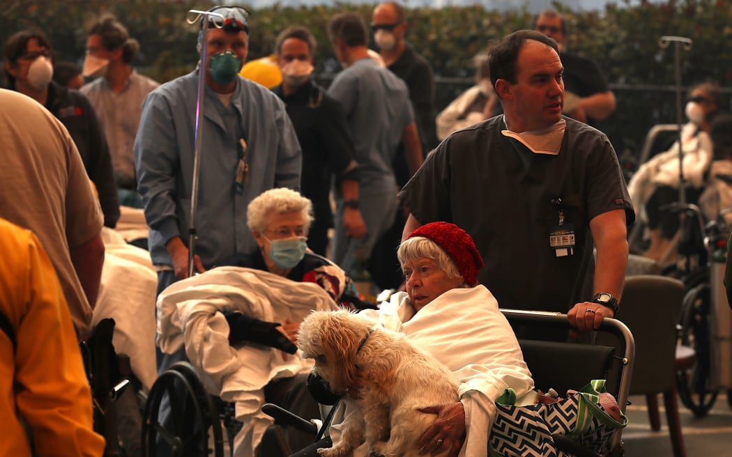 Hospital workers and first responders evacuate patients from the Feather River Hospital as the Camp Fire moves through the area