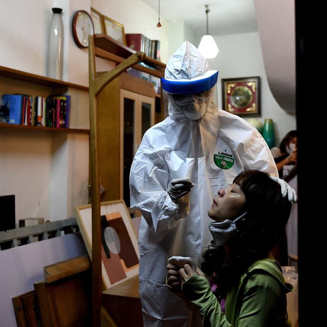 A health worker tests a woman for Covid-19 in her house in Hanoi, Vietnam's capital city.
