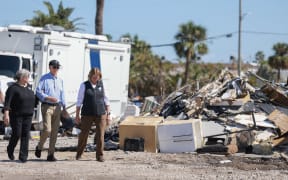ST PETE BEACH, FLORIDA - OCTOBER 13: U.S. President Joe Biden walks with Pinellas County Emergency Director Cathie Perkins and Deanne Criswell (R), Administrator of the U.S. Federal Emergency Management Agency, during a tour of the damage caused by Hurricane Milton on October 13, 2024 in St Pete Beach, Florida. Biden visited the area as it deals with back-to-back hurricanes that have caused extensive damage.   Joe Raedle/Getty Images/AFP (Photo by JOE RAEDLE / GETTY IMAGES NORTH AMERICA / Getty Images via AFP)
