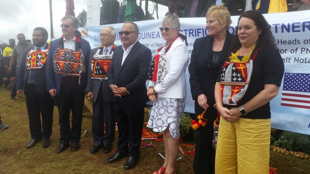 PNG prime minister Peter O'Neill (middle with shaded glasses) surrounded by diplomats (including New Zealand's High Commissioner Sue Mackwell in white jacket) and PNG Power managing director Carolyn Blacklock (far right)  officially launches a $US1.7 billion electrification project for PNG in Okapa