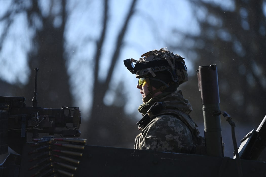 A Ukrainian soldier in an armoured vehicle waits on the west side of the Ukrainian capital of Kyiv on February 26, 2022.