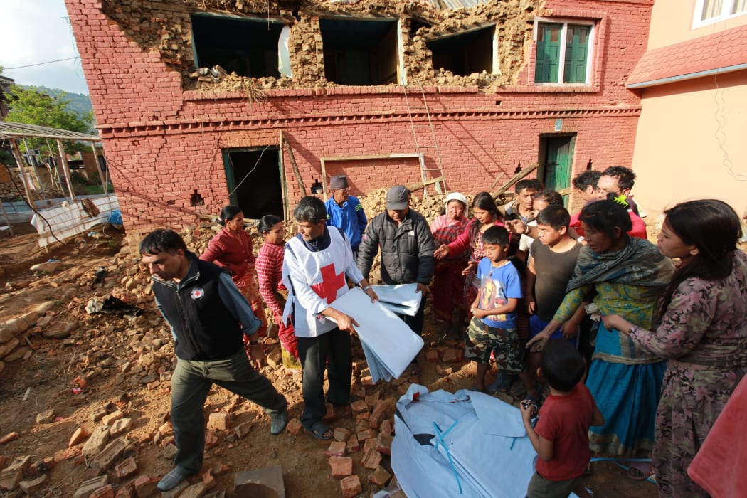 Members of the Nepal Red Cross distribute tarpaulins to displaced residents in Kathmandu on 27 April.