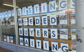 A sign in a real estate window in Dargaville, looking for house listings.